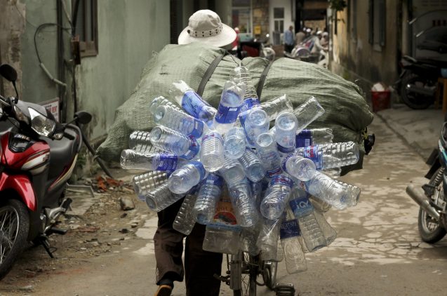person in vietnam carrying plastic water bottles