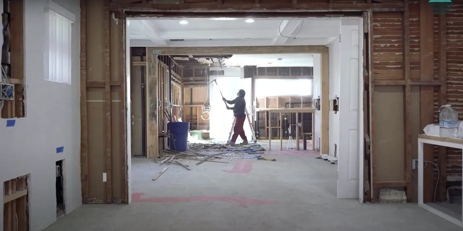 A person does construction work inside a building.