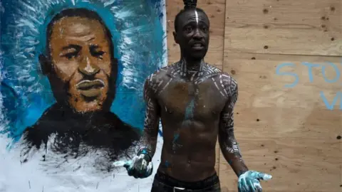 Getty Images A man paints a portrait of George Floyd on June 2, 2020 in Los Angeles, California