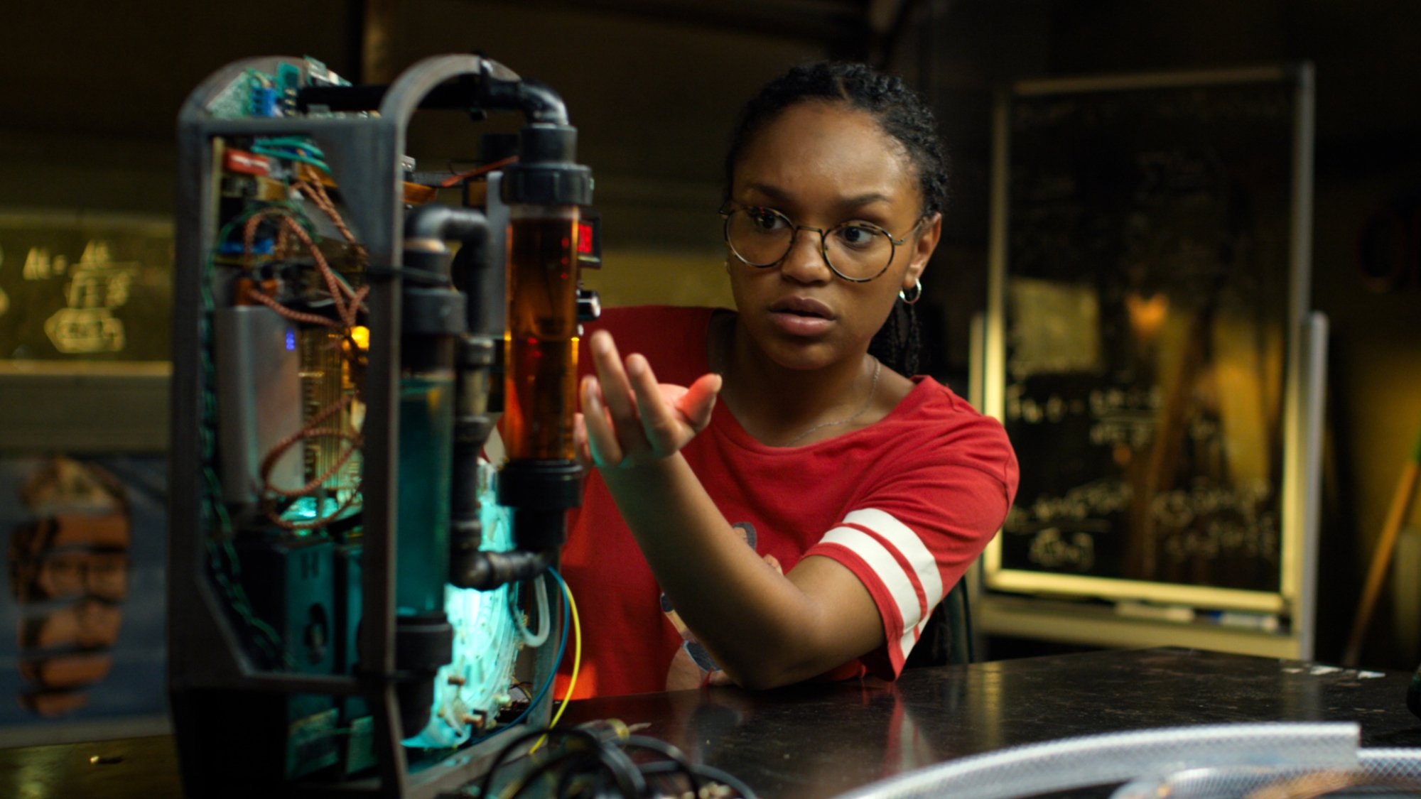 A girl works on an electronic project in a garage. 
