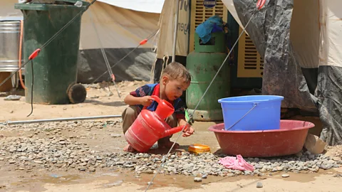 Getty Images A boy washes at the Dibege Refugee Camp in Iraq; ensuring that there are handwashing stands and soap is key to fighting Covid-19’s spread in refugee camps (Credit: Getty Images)