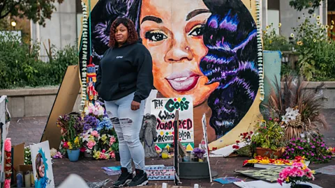 Brandon Bell/ Getty Images Tamika Palmer, the mother of Breonna Taylor, stands in front of a mural of her daughter in Louisville, Kentucky (Credit: Brandon Bell/ Getty Images)