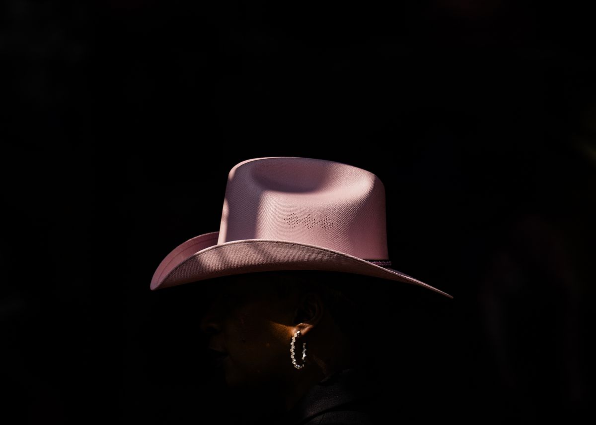 A woman wears a pink cowboy hat and earrings during the Houston Livestock Show and Rodeo at NRG Park.
