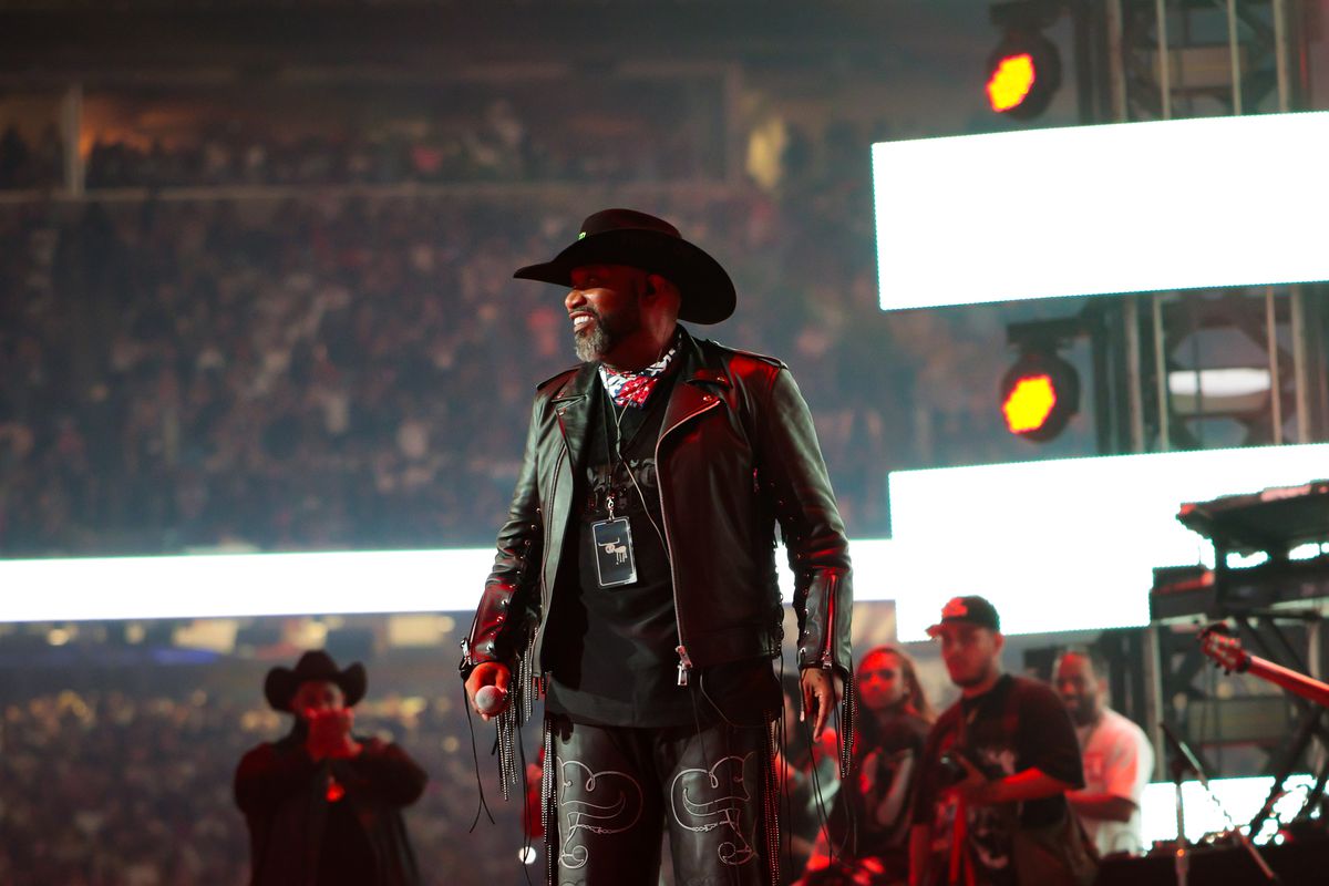 Rapper Bun B performs in a cowboy hat at his annual All-American Takeover at this year’s Houston Rodeo. He’s wearing a black cowboy hat, a black leather jacket with fringe, and Black pant pants with various designs.